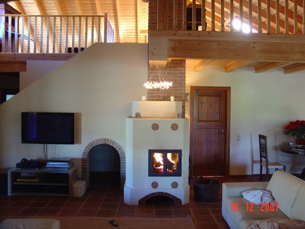 Der verputzte Ofen 'Barão' beheizt komplett ein grosses Steinhaus

