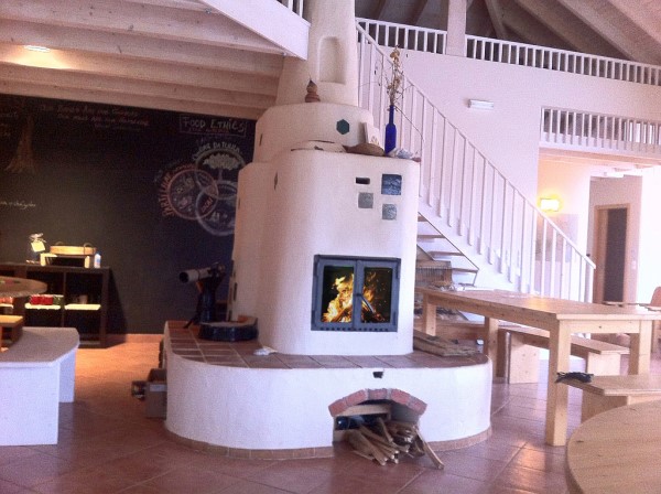 Grosser Grundofen mit Kachelelementen Er steht im Fruehstueksraum eine Hotels und kann mittels         Waermeaustauscher die Arpartments beheitzen.
